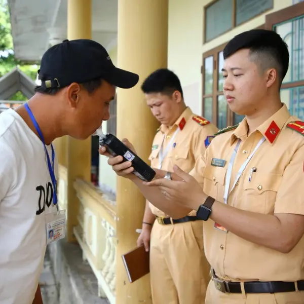 Công an đo nồng độ cồn học viên trước giờ thi sát hạch bằng lái xe
